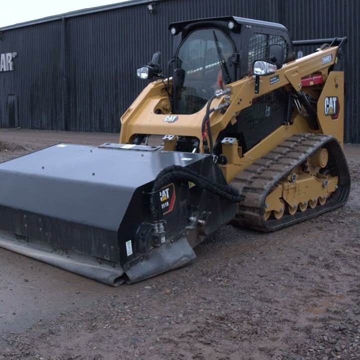 Grading equipment smoothing a rutted dirt driveway after heavy rain damage