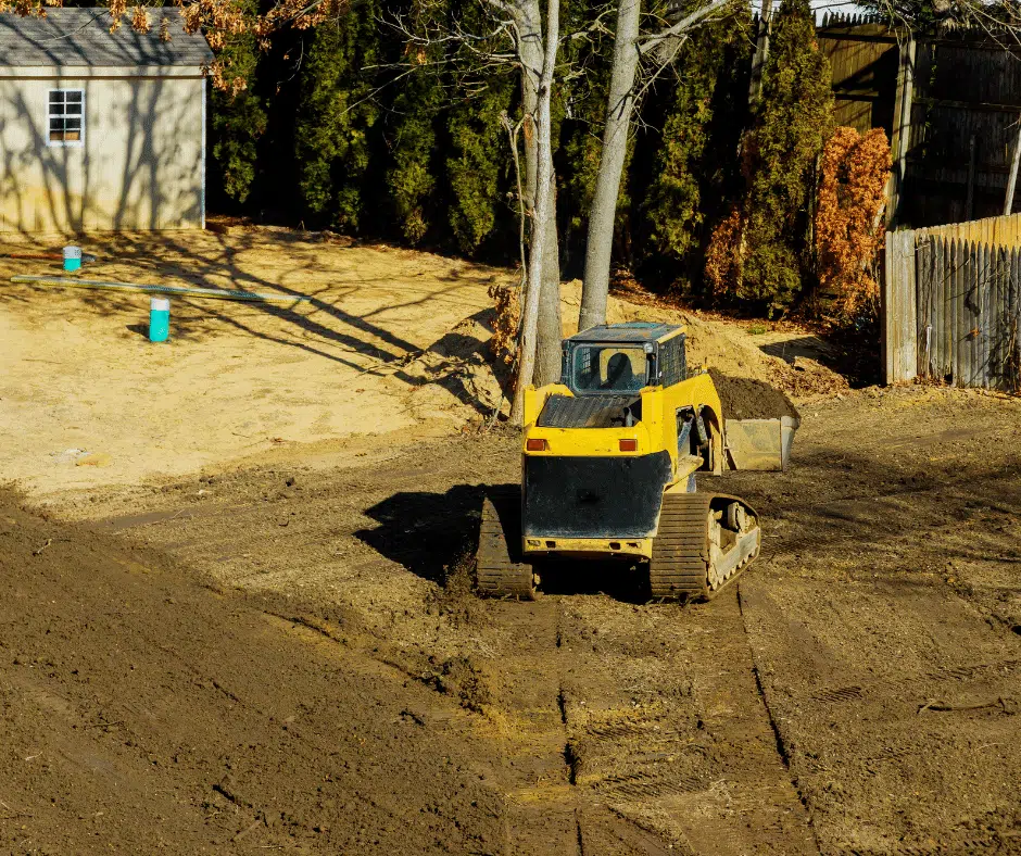 Operator carefully grading a long uneven driveway to restore proper slope